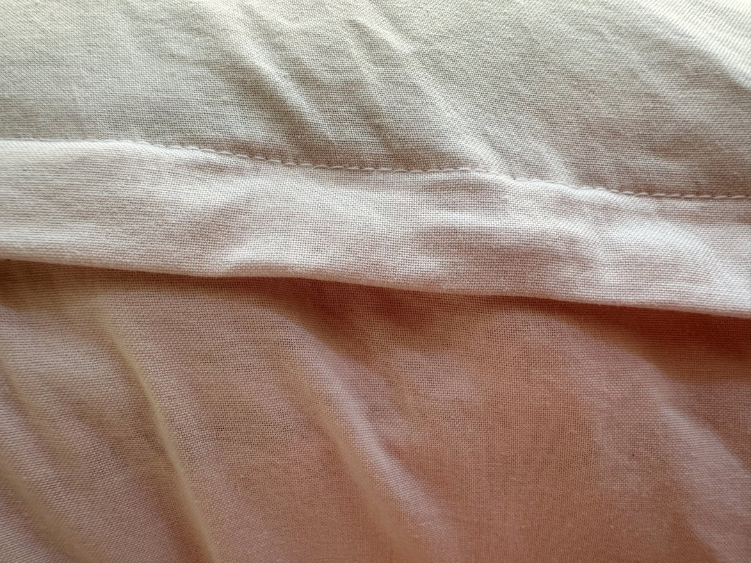 Topstitched envelope flap on the back of the Baby Pink nursing pillow cover, washed cotton texture up close
