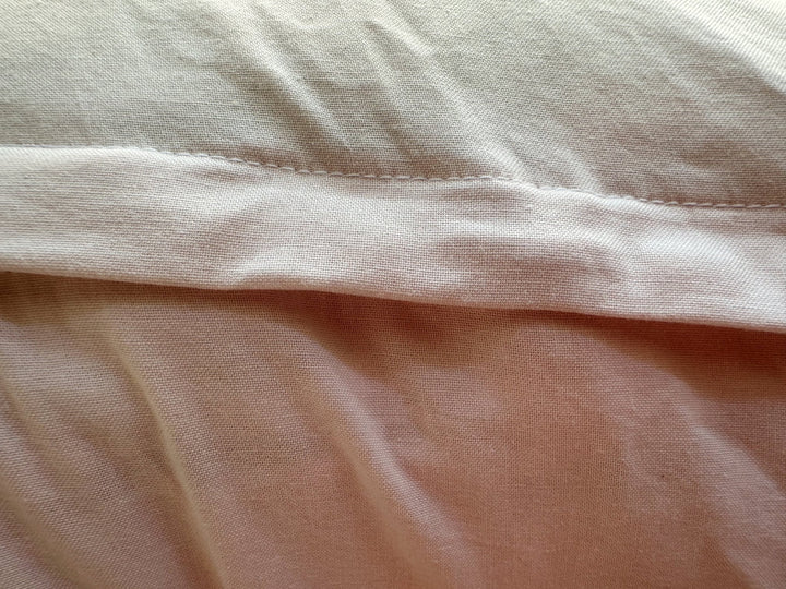 Topstitched envelope flap on the back of the Baby Pink nursing pillow cover, washed cotton texture up close
