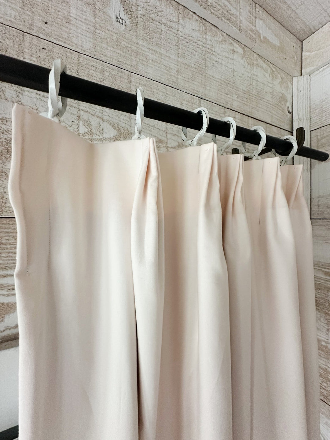 Euro pleat header and white curtain rings seen from below, the panel falling in even folds