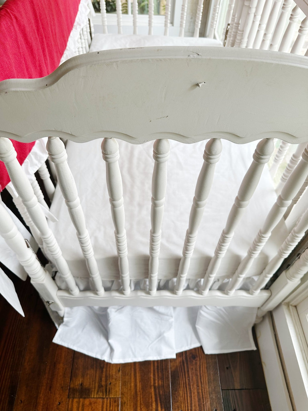 Overhead view from the end of the crib with the red rail cover at the edge of the frame