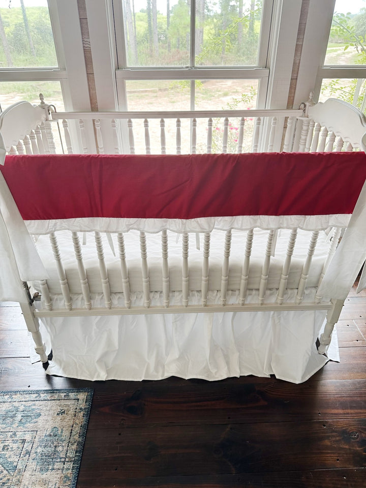Straight-on view of the red rail cover showing the white ruffle edge and slim white ties