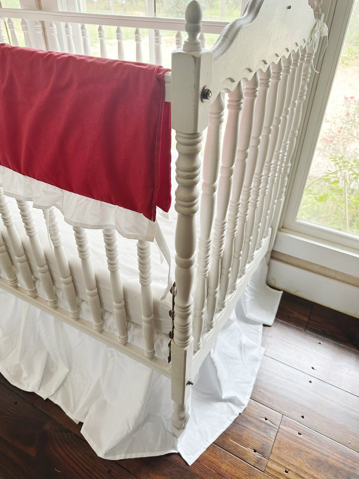 The red rail cover ending at the corner post above the white farmhouse skirt