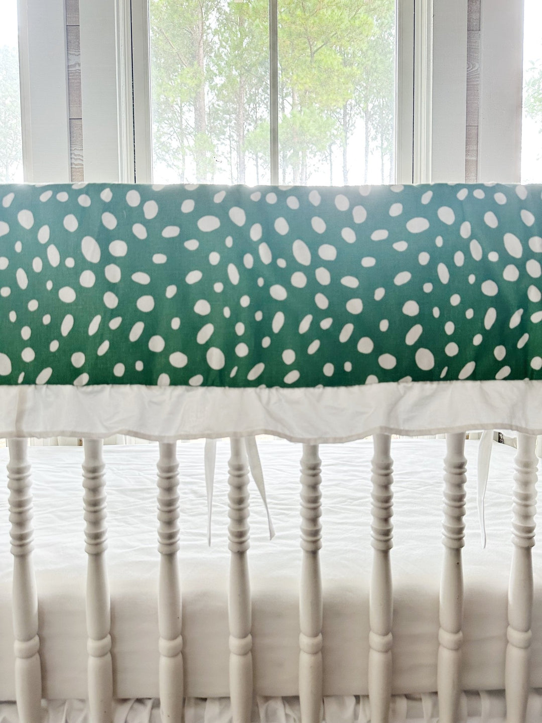 Close view of the irregular white spots on deep green cotton above the gathered white ruffle