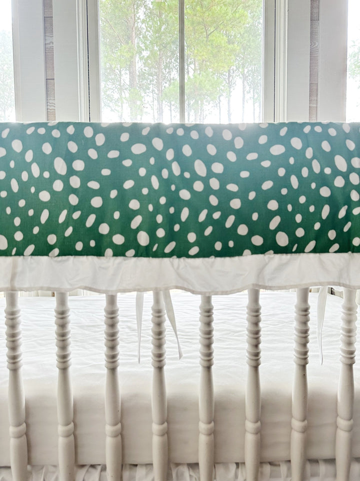 Close view of the irregular white spots on deep green cotton above the gathered white ruffle