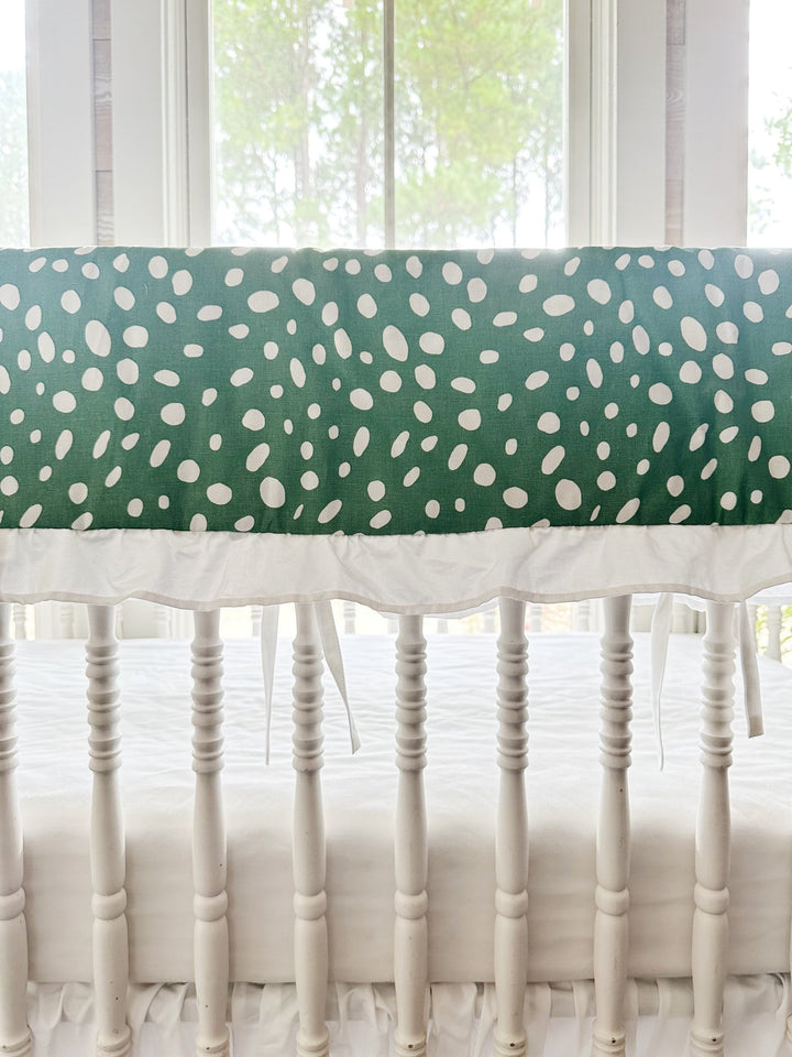 Close view of the irregular white spots on deep green cotton above the gathered white ruffle