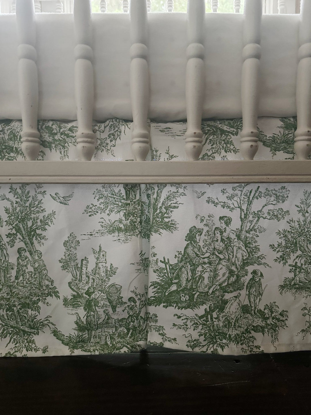Close view of the green toile skirt showing the pastoral scene and the crisp box pleat