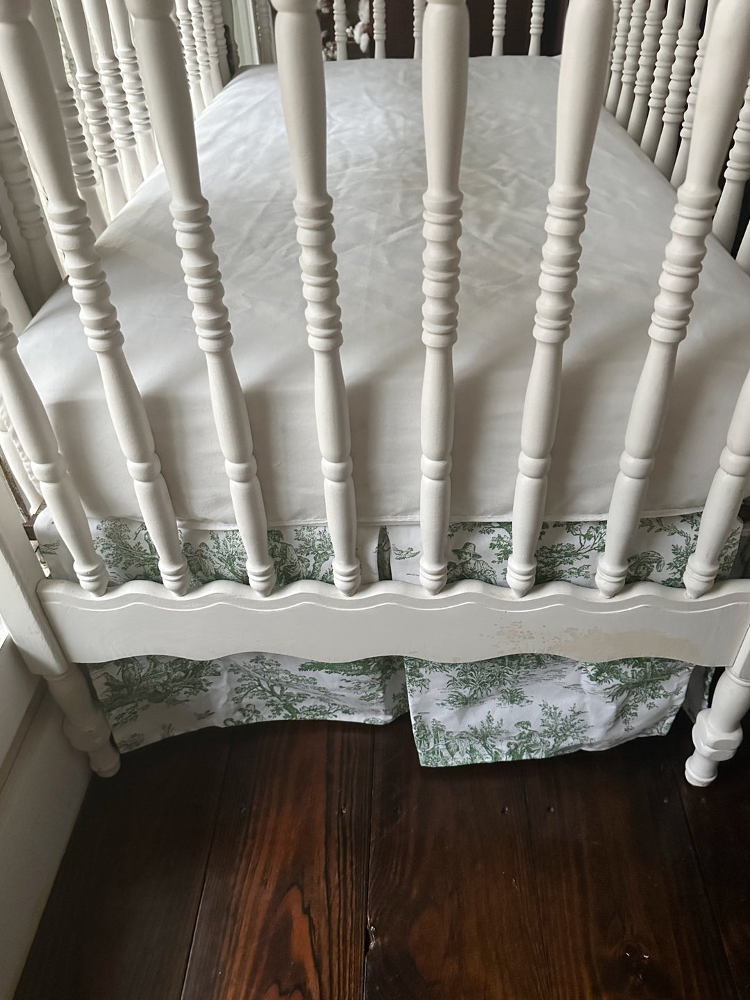 End of the crib showing the full 20-inch drop of the green toile skirt