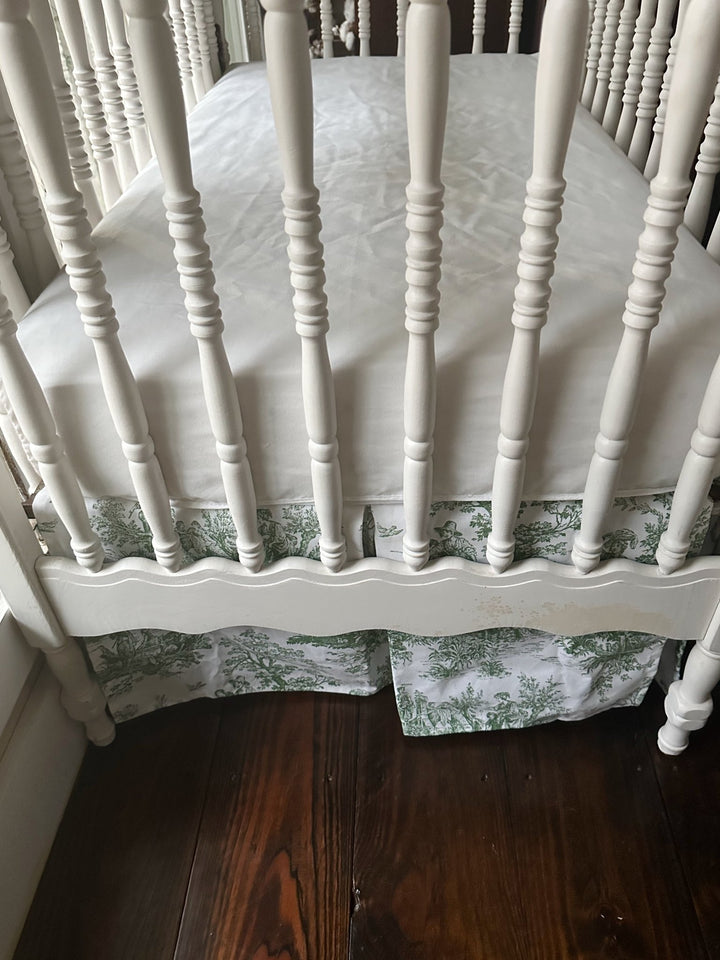 End of the crib showing the full 20-inch drop of the green toile skirt