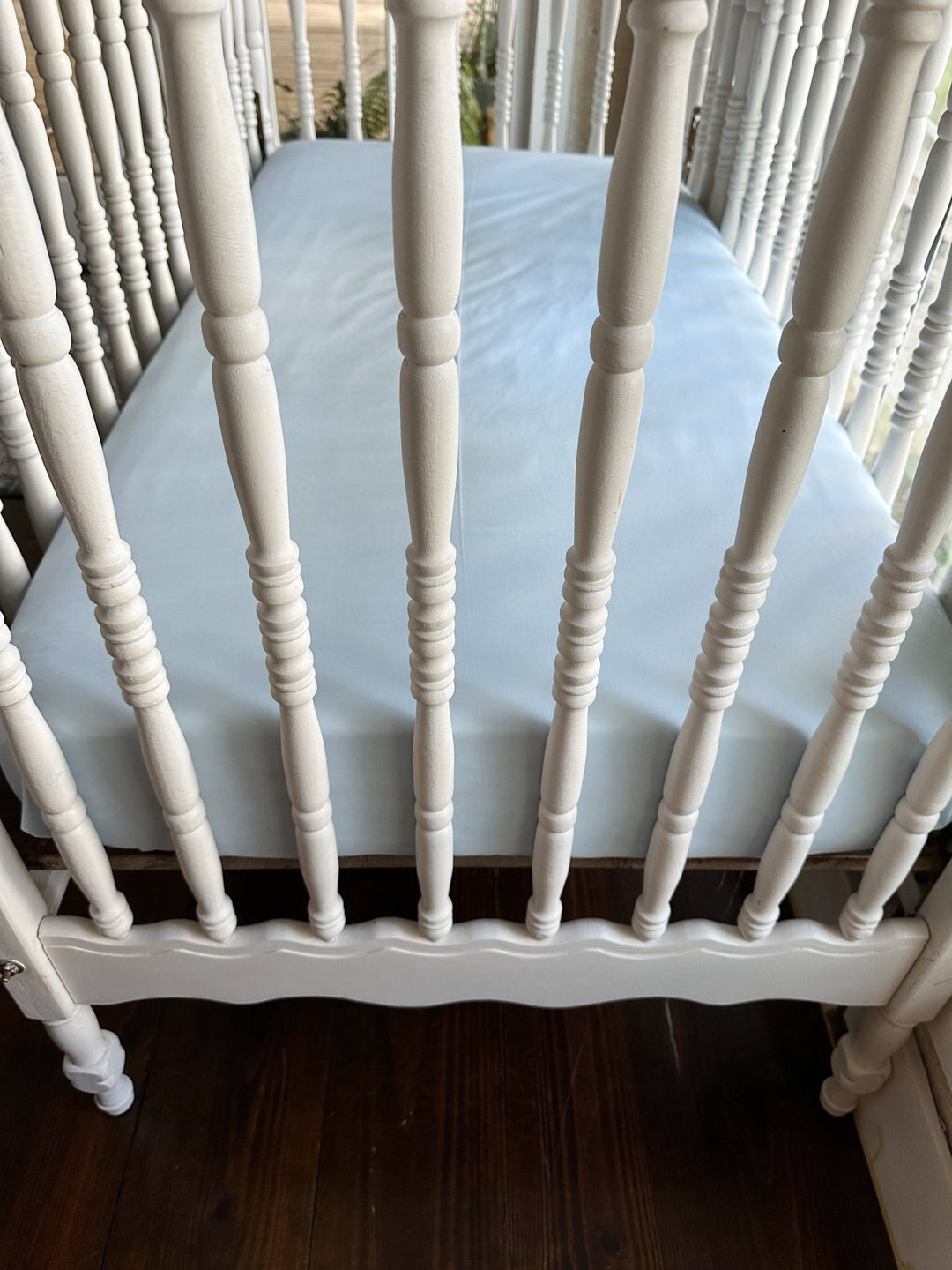 Foot end of the crib showing the Heirloom Blue fitted crib sheet tucked smoothly over the mattress corners - High Cotton Textile