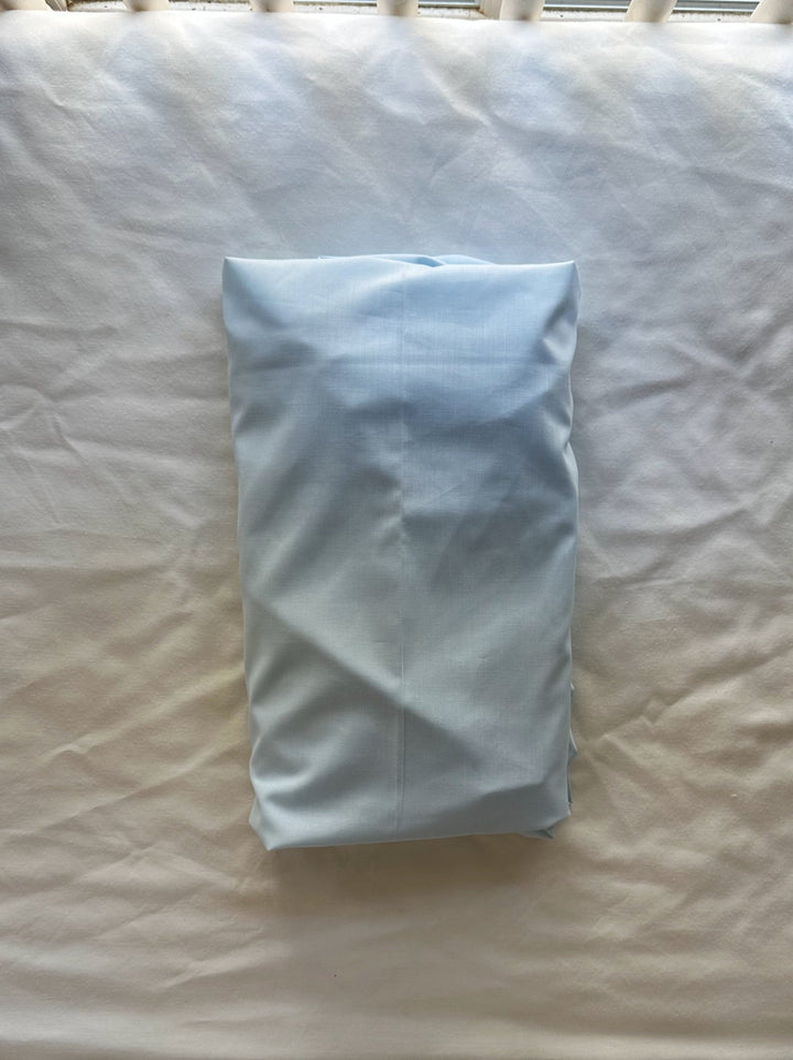 Heirloom Blue fitted crib sheet folded and laid on the crib mattress, showing the washed cotton fabric - High Cotton Textile