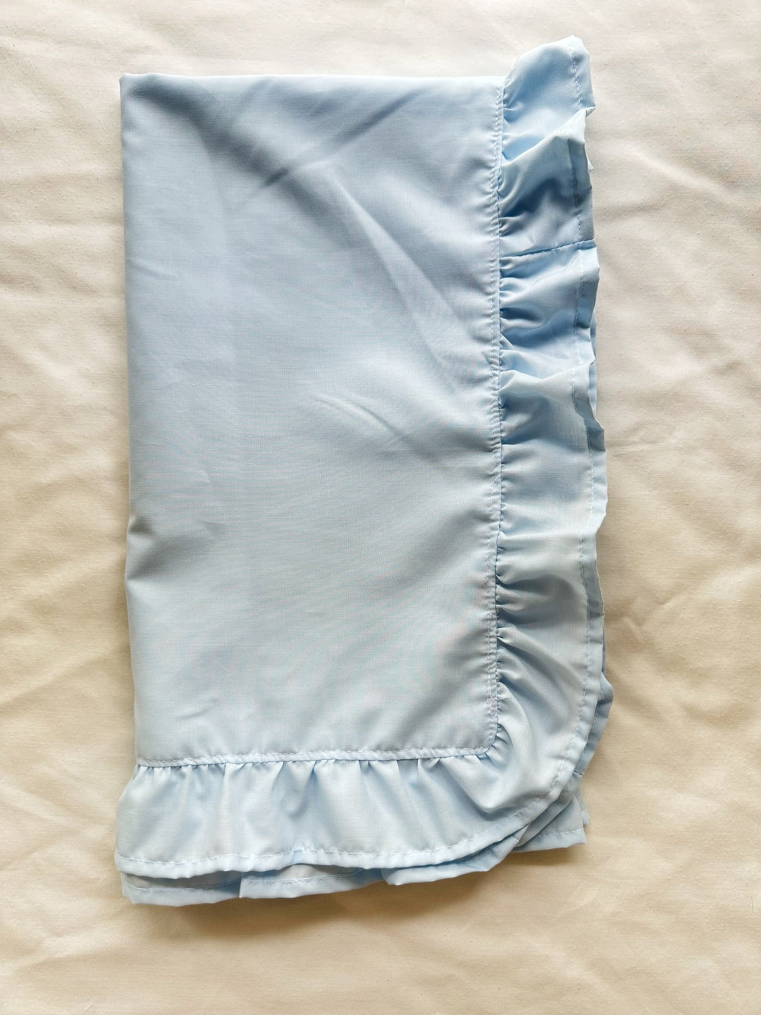 Folded heirloom blue ruffled crib blanket in soft 100% washed cotton - High Cotton Textile
