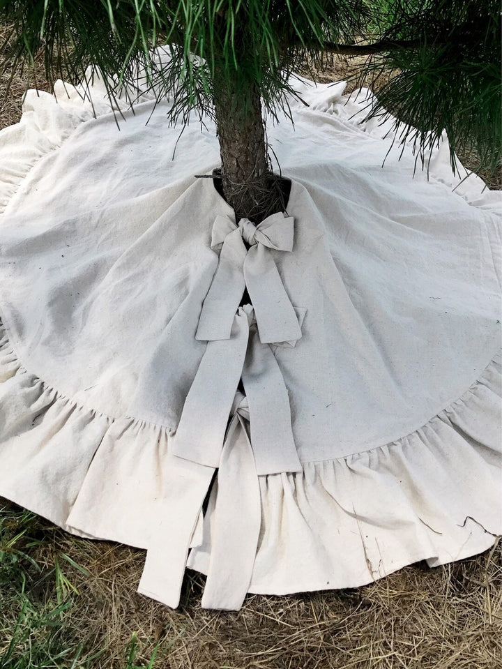 Looking down on the tree skirt's center opening, long natural cotton ties falling from two tied bows