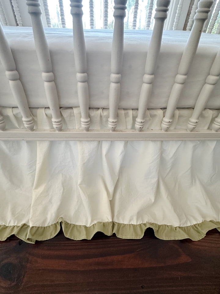 Detail of the sage green ruffle hem and gathered ivory washed cotton on a handmade crib skirt