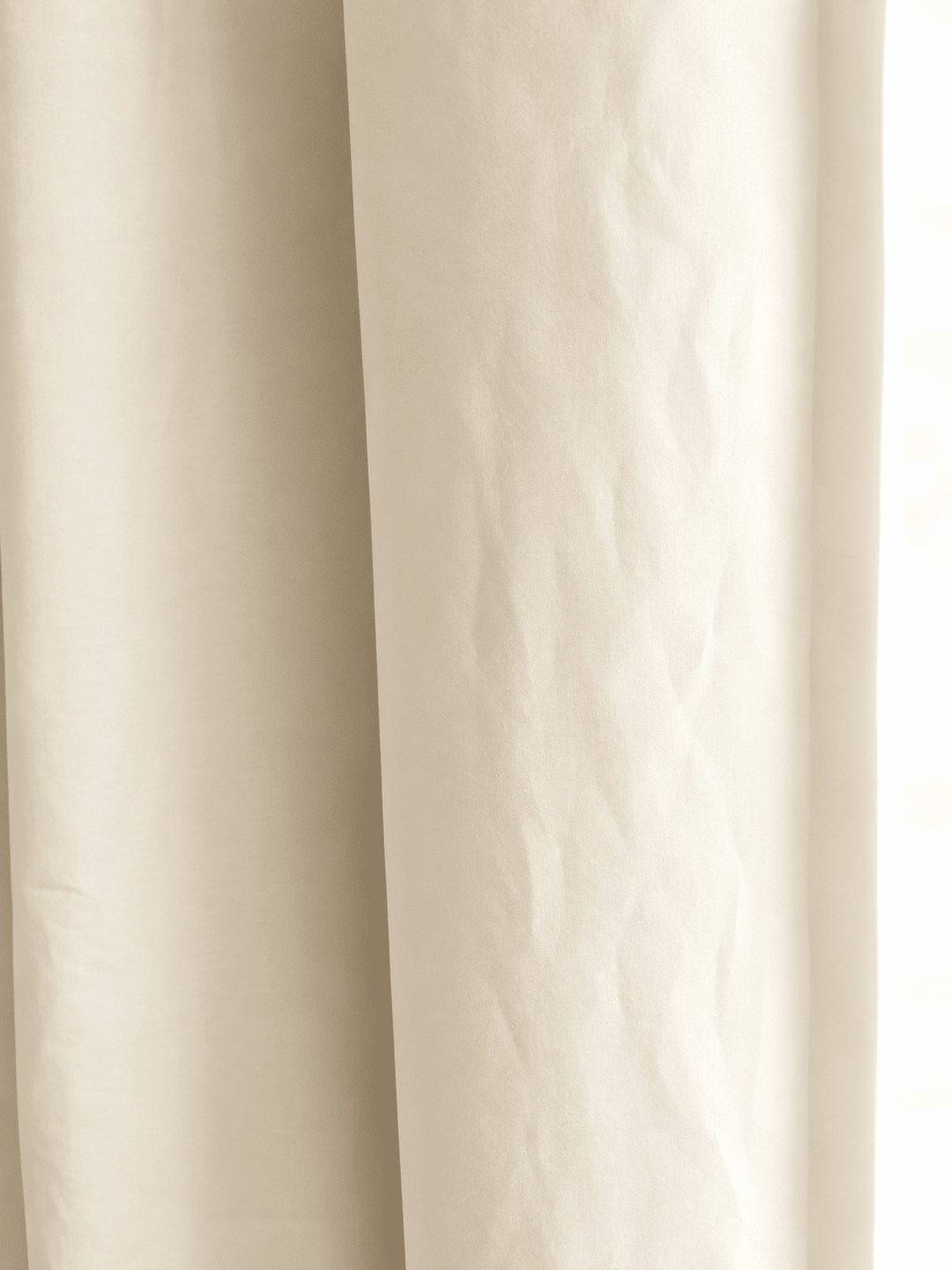 Close view of soft ivory washed cotton, showing the weave and the gentle fold of the panel