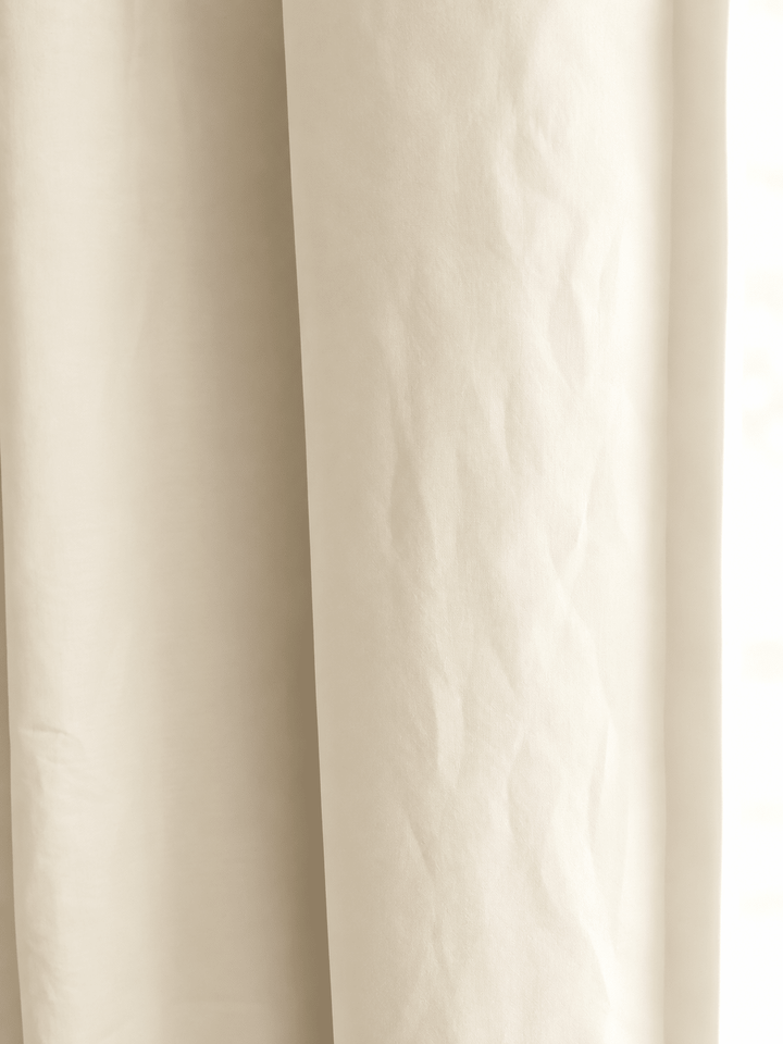 Close view of soft ivory washed cotton, showing the weave and the gentle fold of the panel
