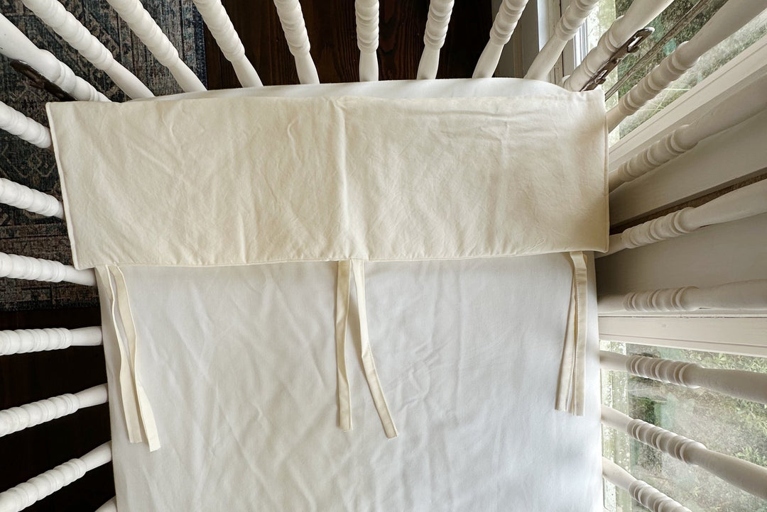 Detail of the ivory rail cover folded open to show the stitched edge and tie placement