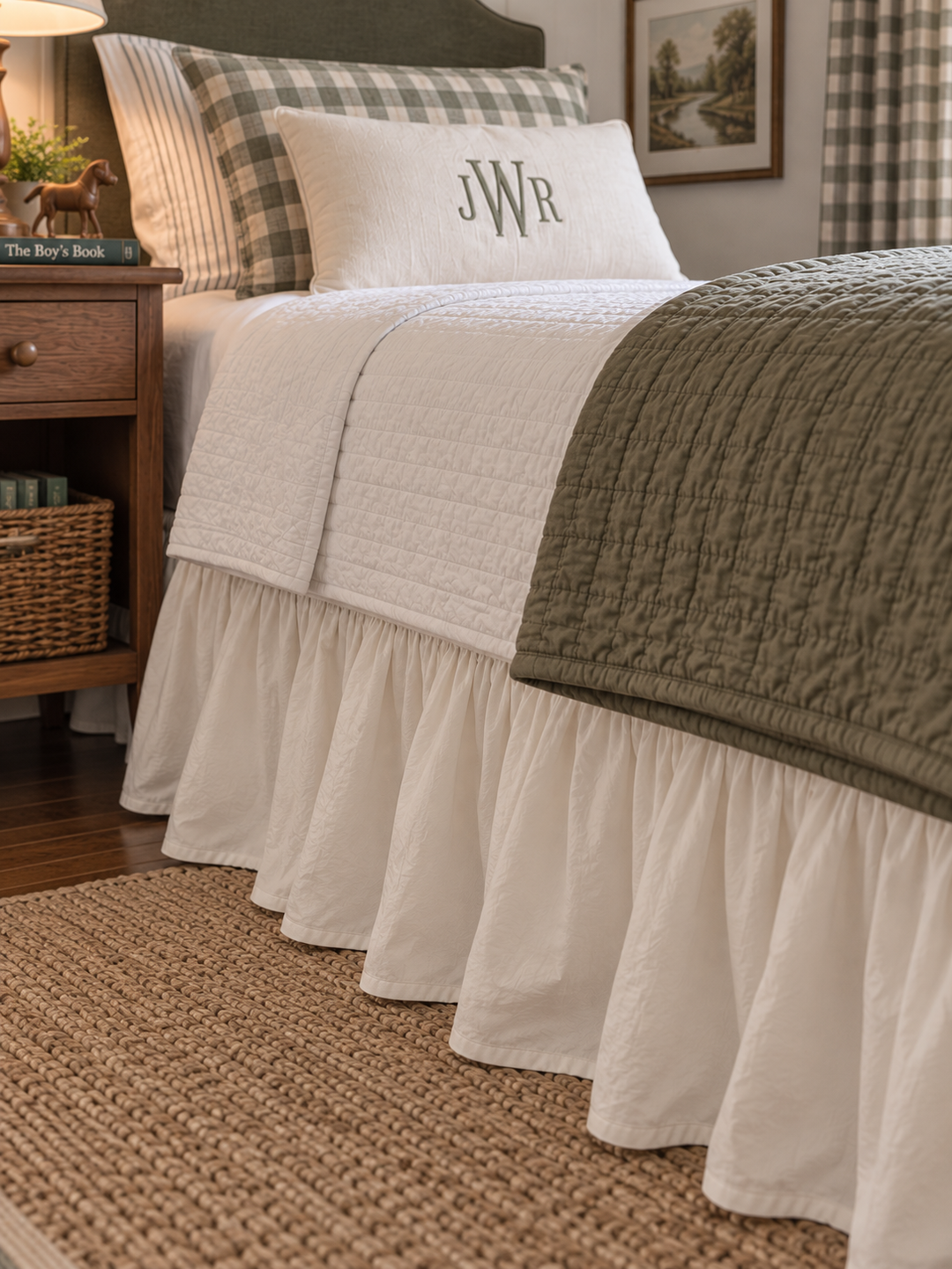 Ivory farmhouse bed skirt gathered along the side of a twin bed above a braided jute rug - High Cotton Textile