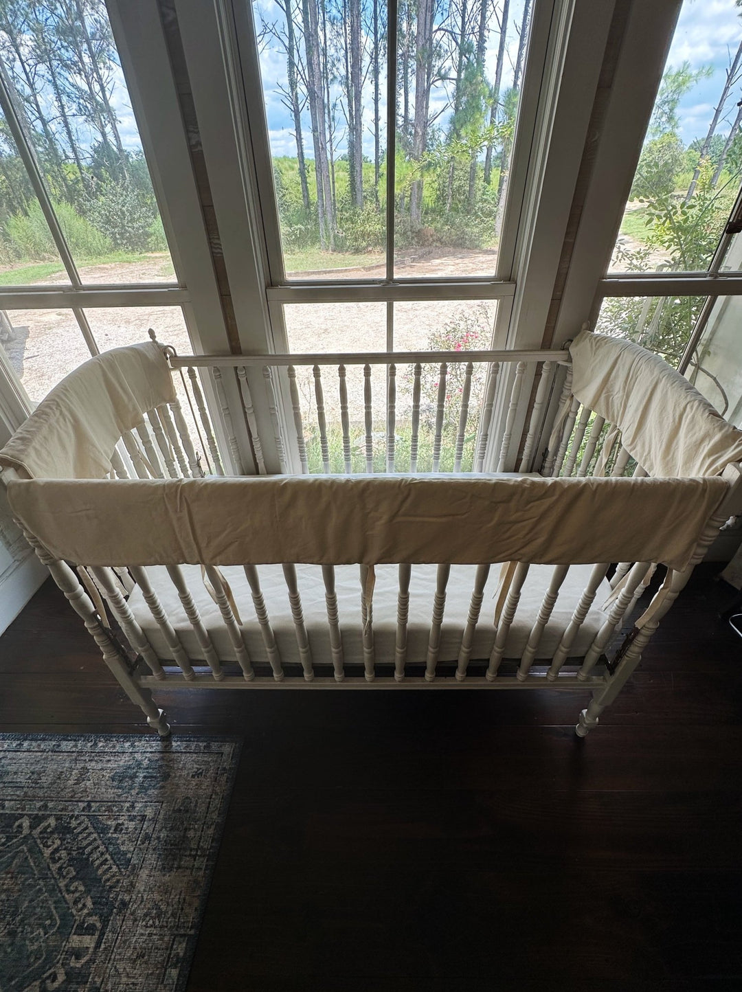 Full crib set of Natural crib rail covers on the long and short top rails of a white wooden crib