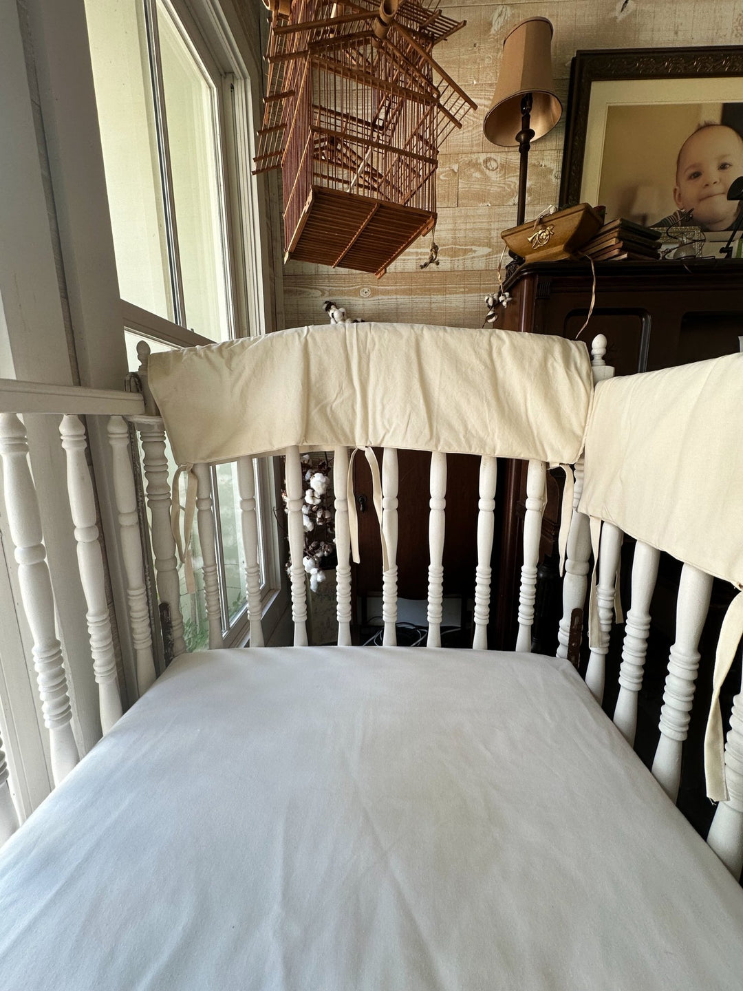 Inside view of a Natural crib rail cover with cotton ties threaded through the crib spindles