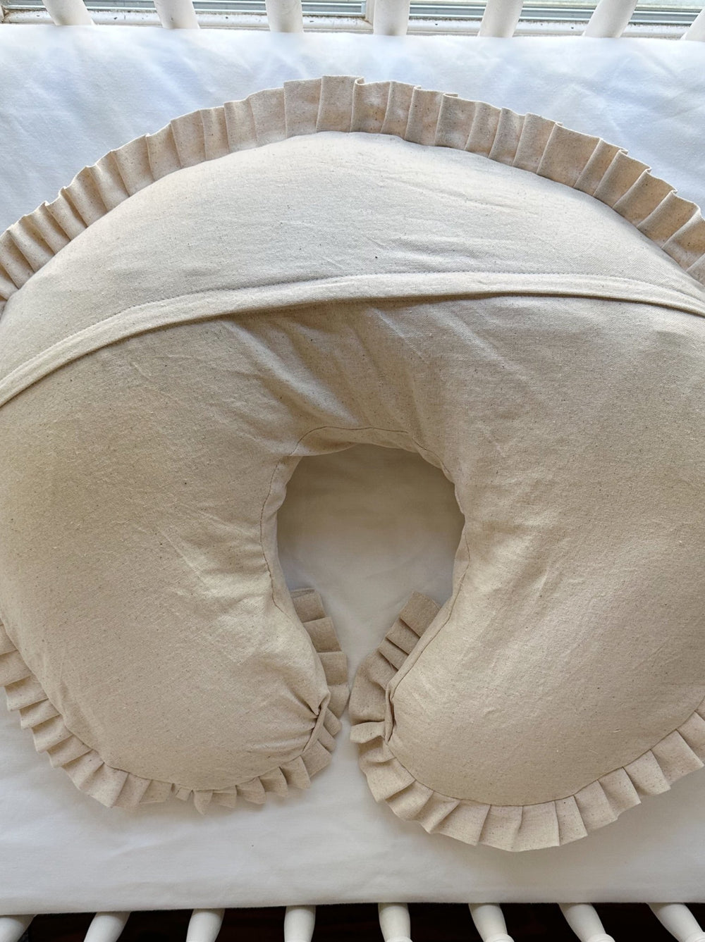 Back of the Natural Osnaburg Boppy pillow cover showing the envelope flap across the curve and the pleated ruffle edge