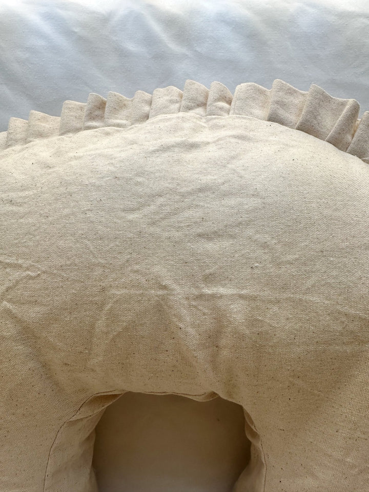 Top of the Natural Osnaburg nursing pillow cover above the inner curve, with the pleated ruffle along the back edge