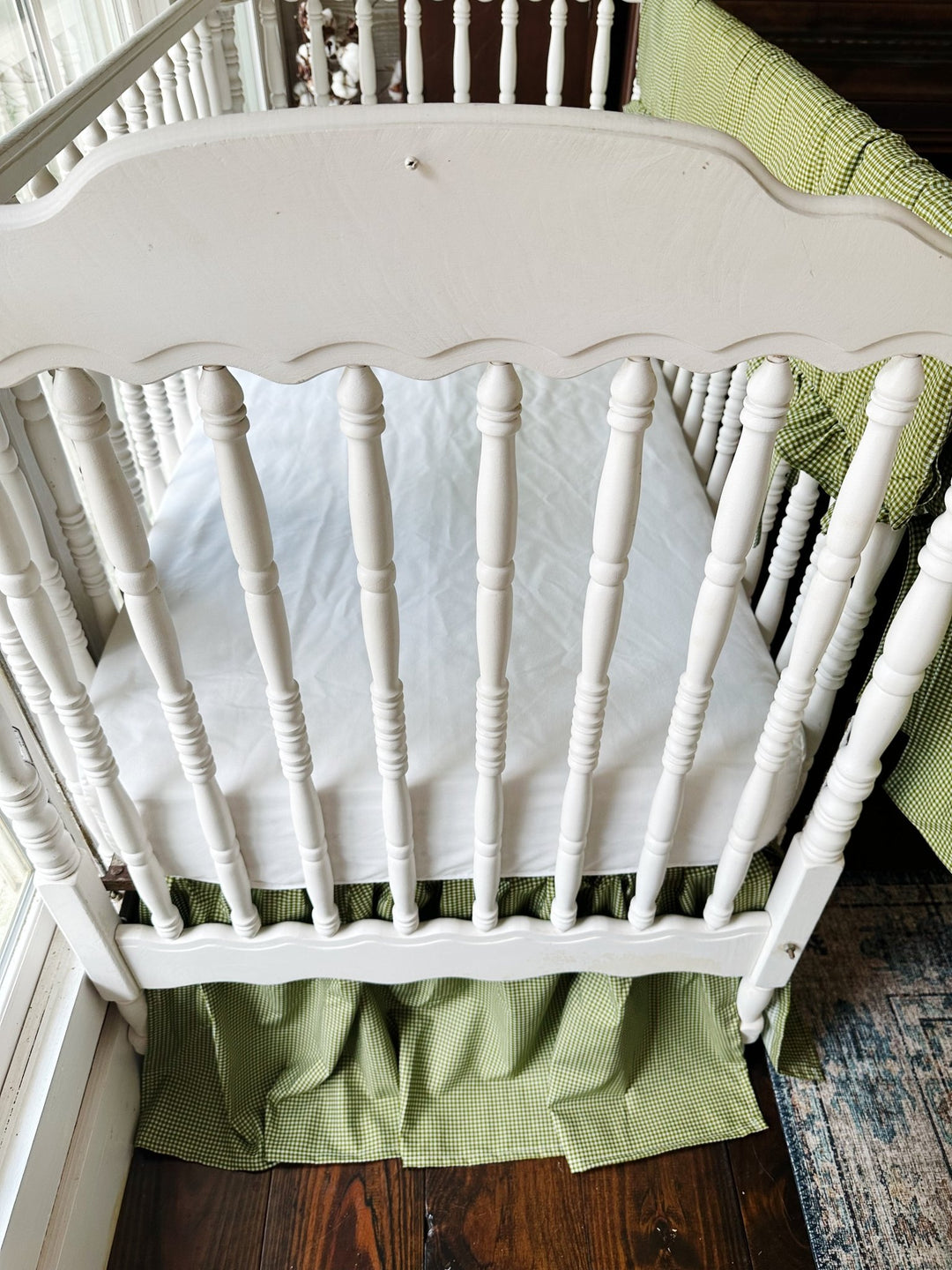 White fitted crib sheet paired with a pine green gingham farmhouse crib skirt