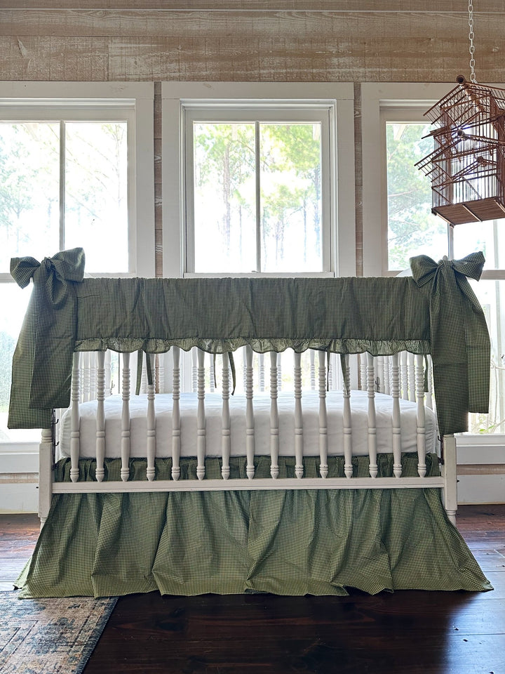 Green gingham crib bedding set styled on a white crib in a farmhouse nursery with pine views