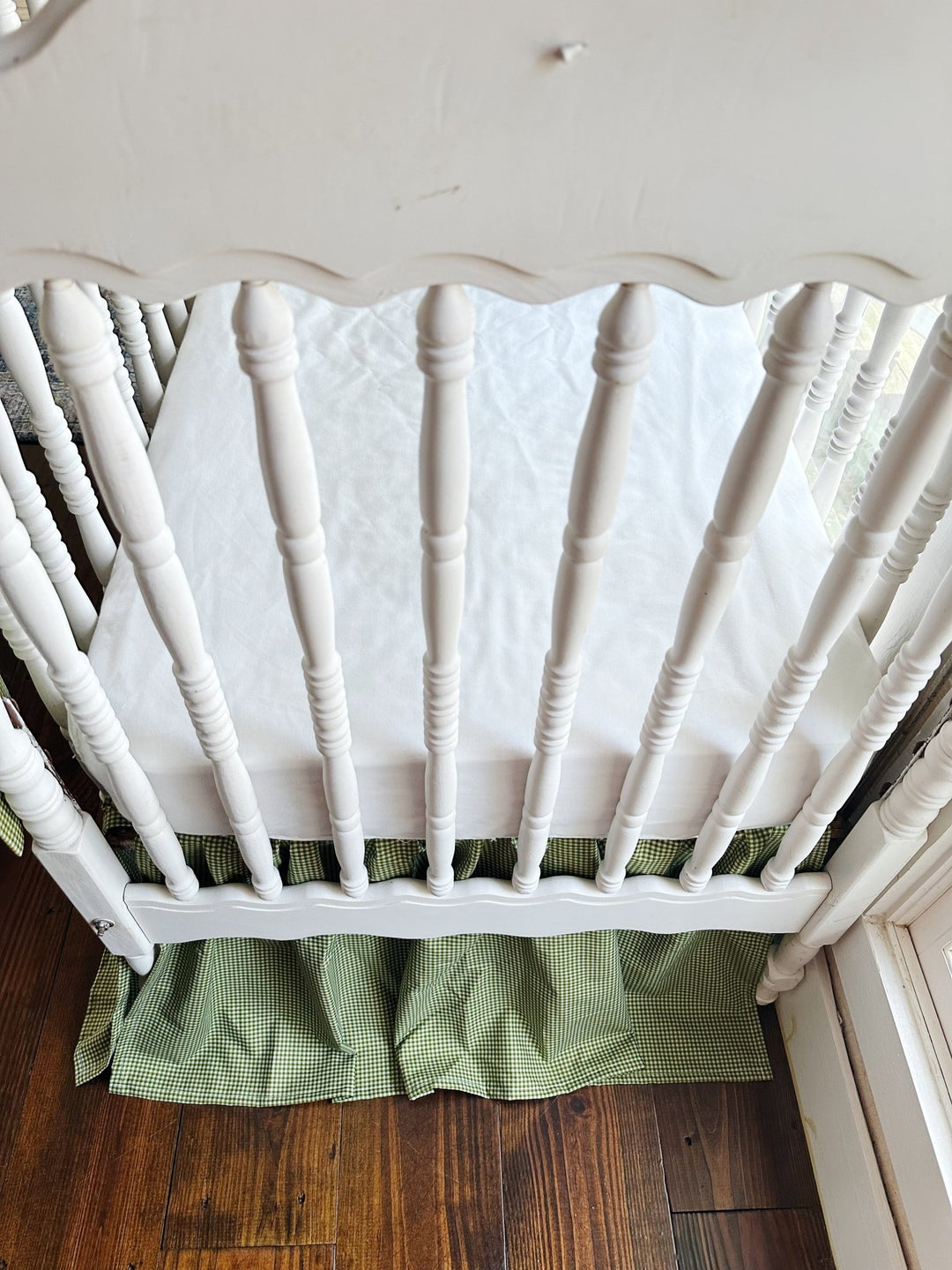 White spindle crib end with the green gingham gathered farmhouse crib skirt