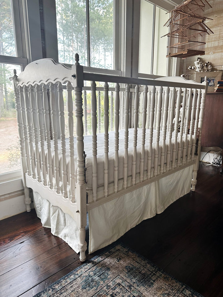 Angled view of the porcelain crib skirt showing the full 20 inch drop along the side of the crib - High Cotton Textile