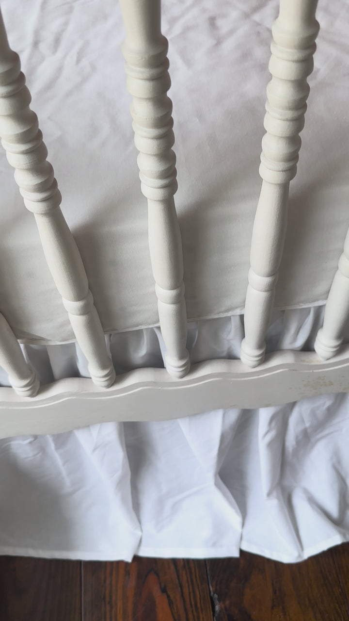 Walking video of the red and white polka dot crib rail cover and white farmhouse crib skirt in the nursery