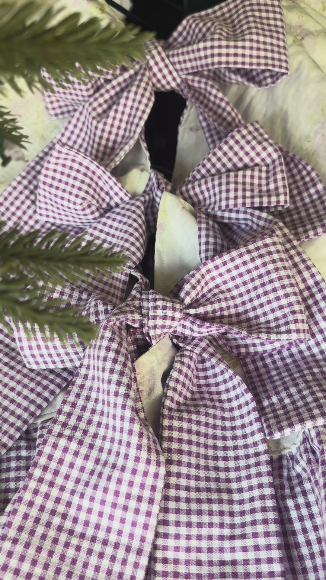 Panning around the lavender floral tree skirt, from the gingham bows at the tree stand to the ruffled edge on a wood floor