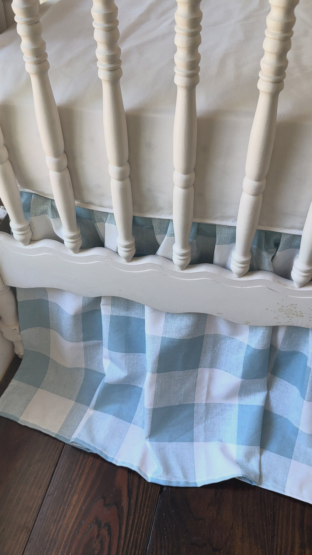 Video of the white scalloped crib rail cover and blue buffalo check crib skirt styled on a farmhouse crib