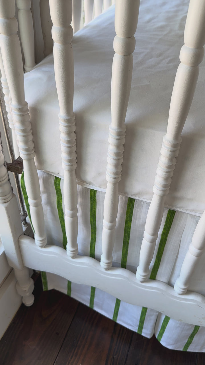 Walking video of the green striped tailored crib rail cover and matching striped crib skirt in the nursery