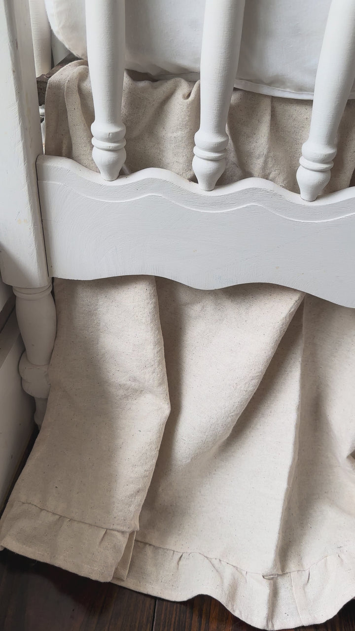 Video of a natural osnaburg ruffled cotton crib skirt on a crib in a neutral nursery - High Cotton Textile