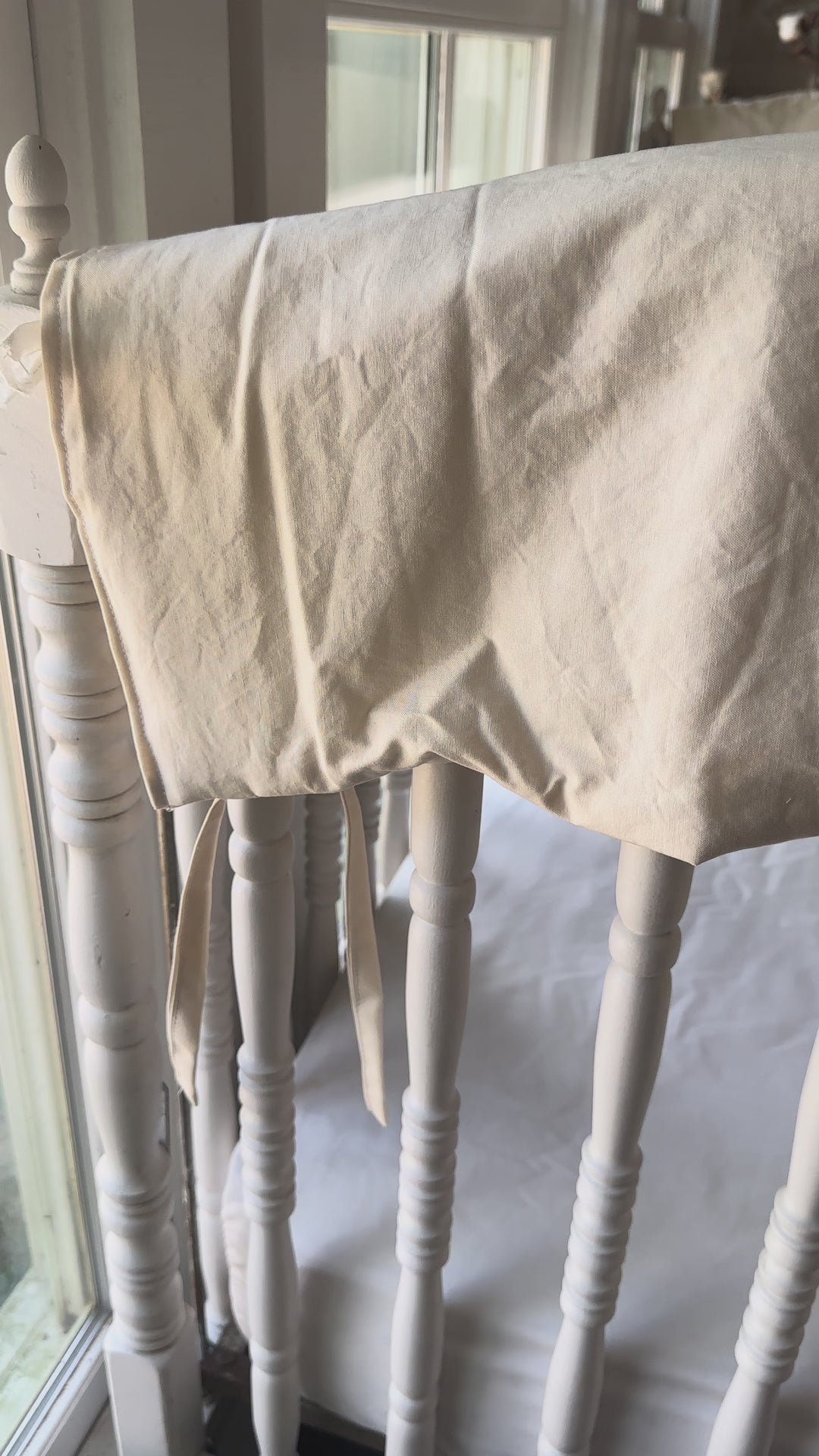 How the Natural crib rail cover lays over the crib top rail and ties through the spindles