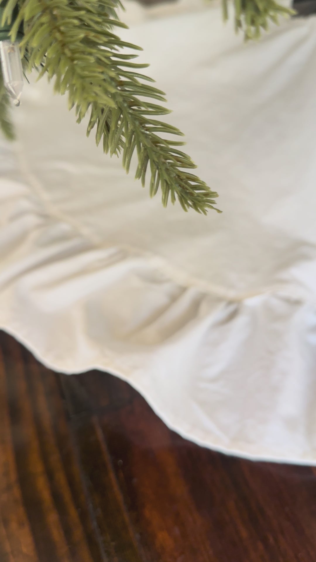 Slow pan across the white ruffled tree skirt to the three tied bows at the front
