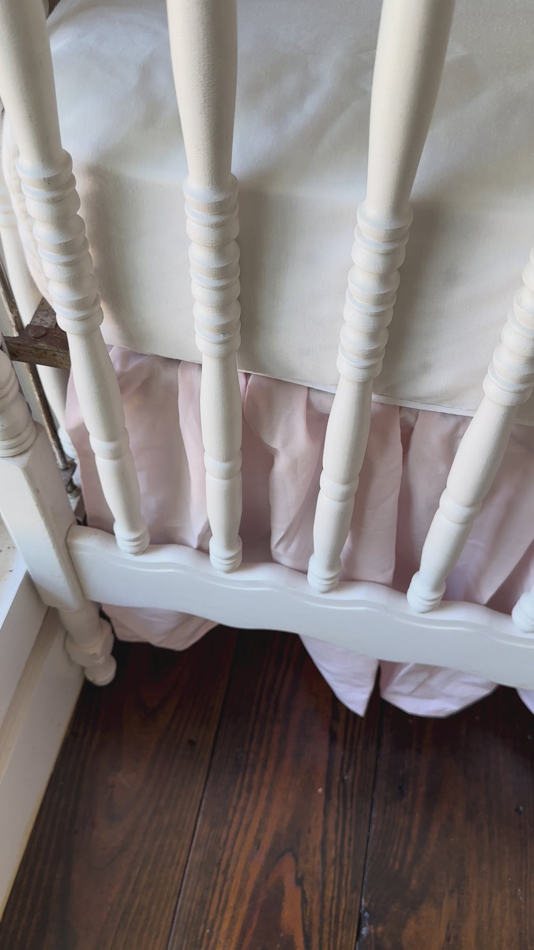 Walking video of the green striped crib rail cover, baby pink farmhouse skirt and pink sashes in the nursery