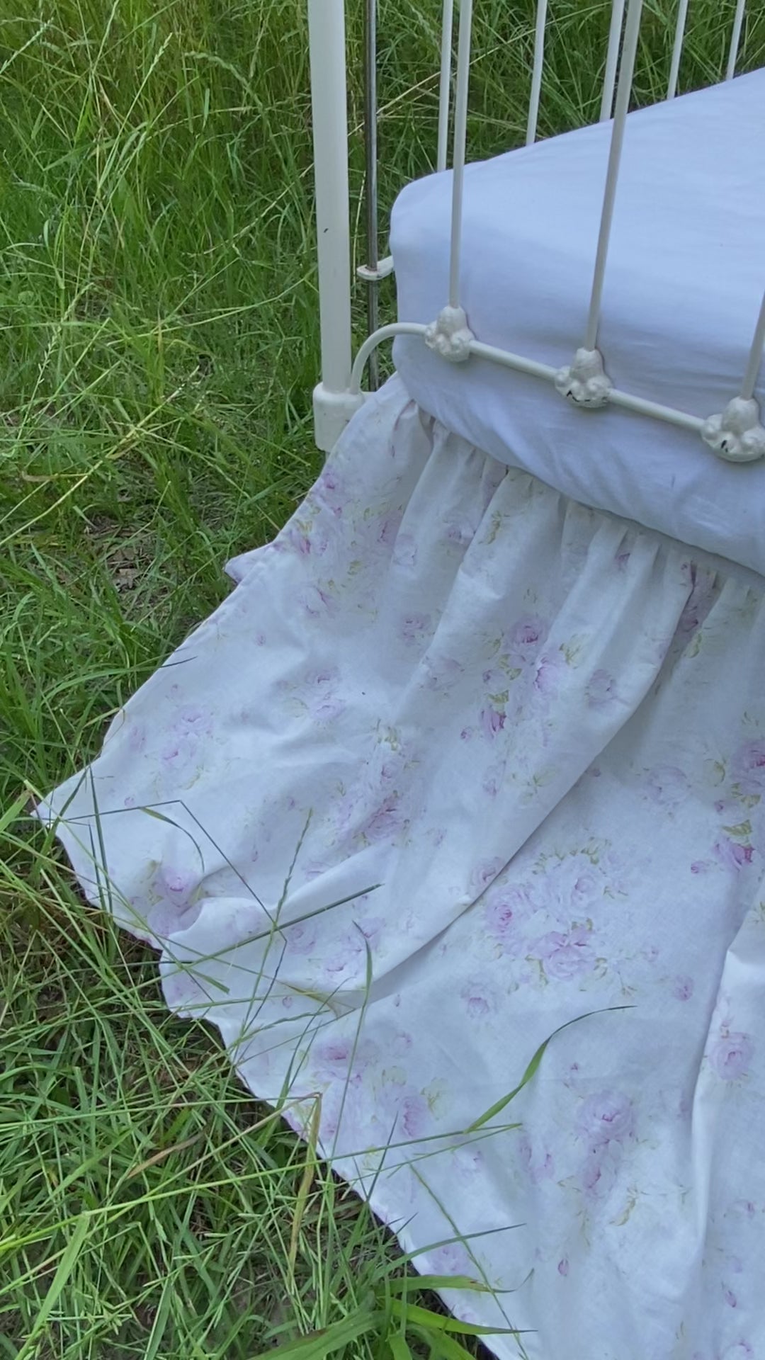 Lavender shabby chic floral gathered crib skirt on antique iron crib in field video