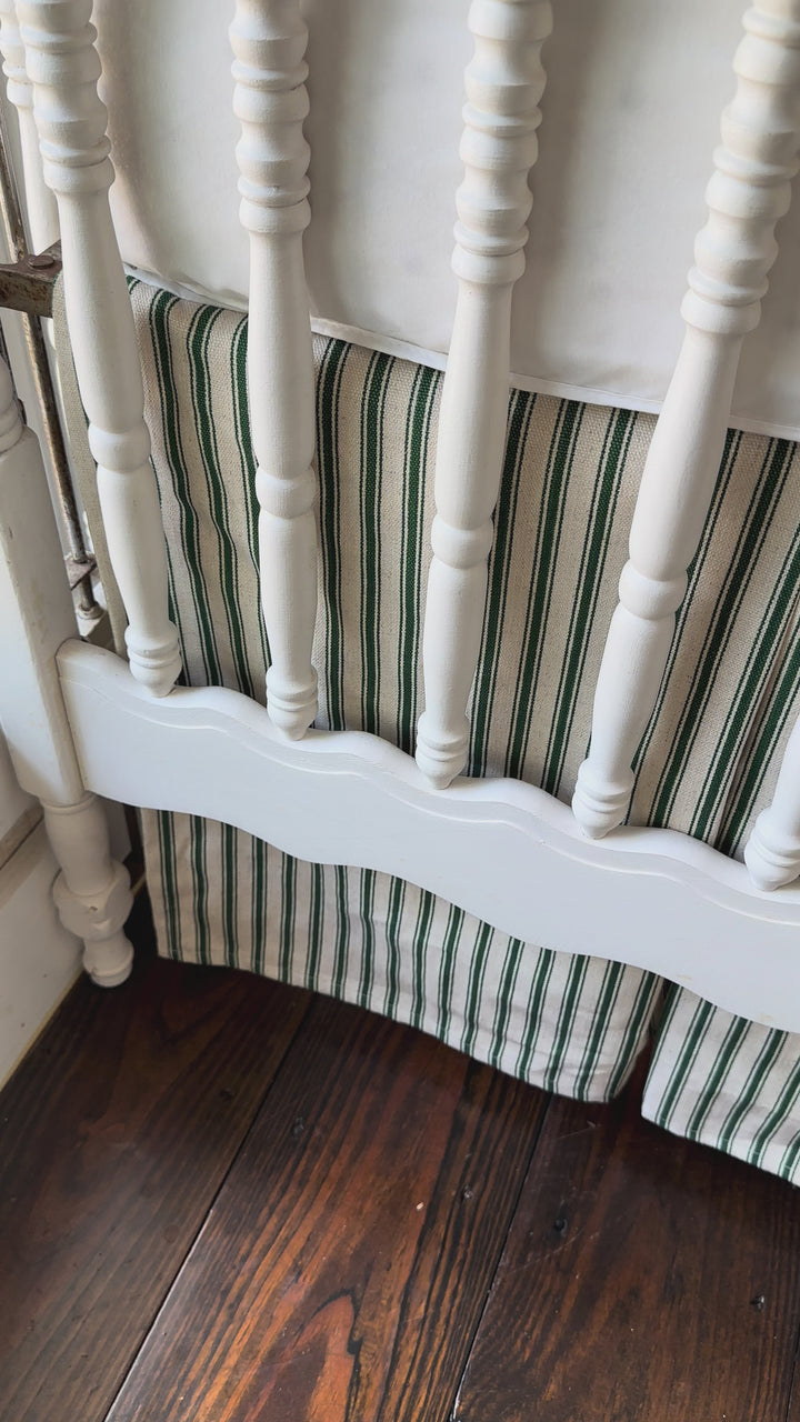 Walking video of the pine green ticking tailored crib skirt with two cypress green sashes at the posts