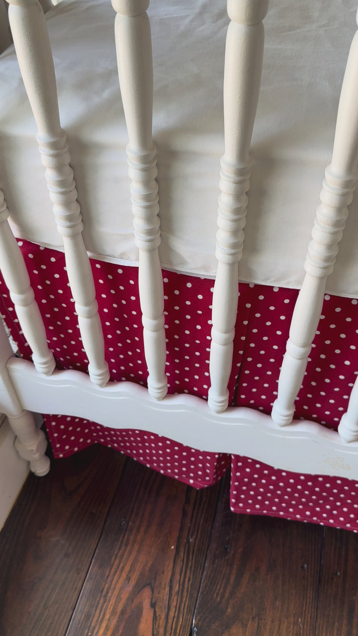 Walking video of the red and white polka dot tailored crib skirt with two white sashes tied at the posts