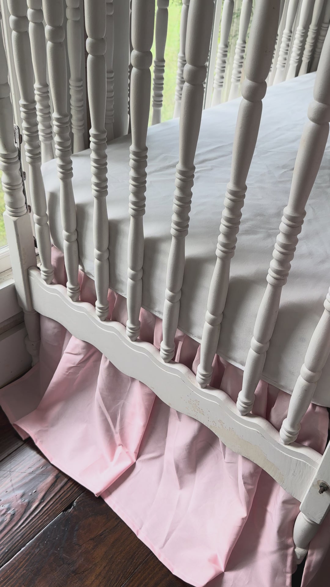 Video of the Sisters Pink farmhouse crib skirt and two large pink crib bows styled on a white spindle crib