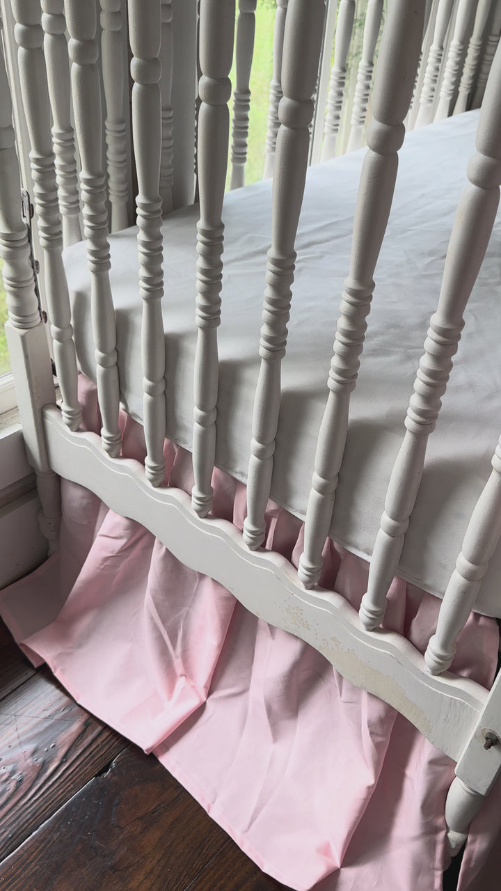 Video of the Sisters Pink farmhouse crib skirt and two large pink crib bows styled on a white spindle crib