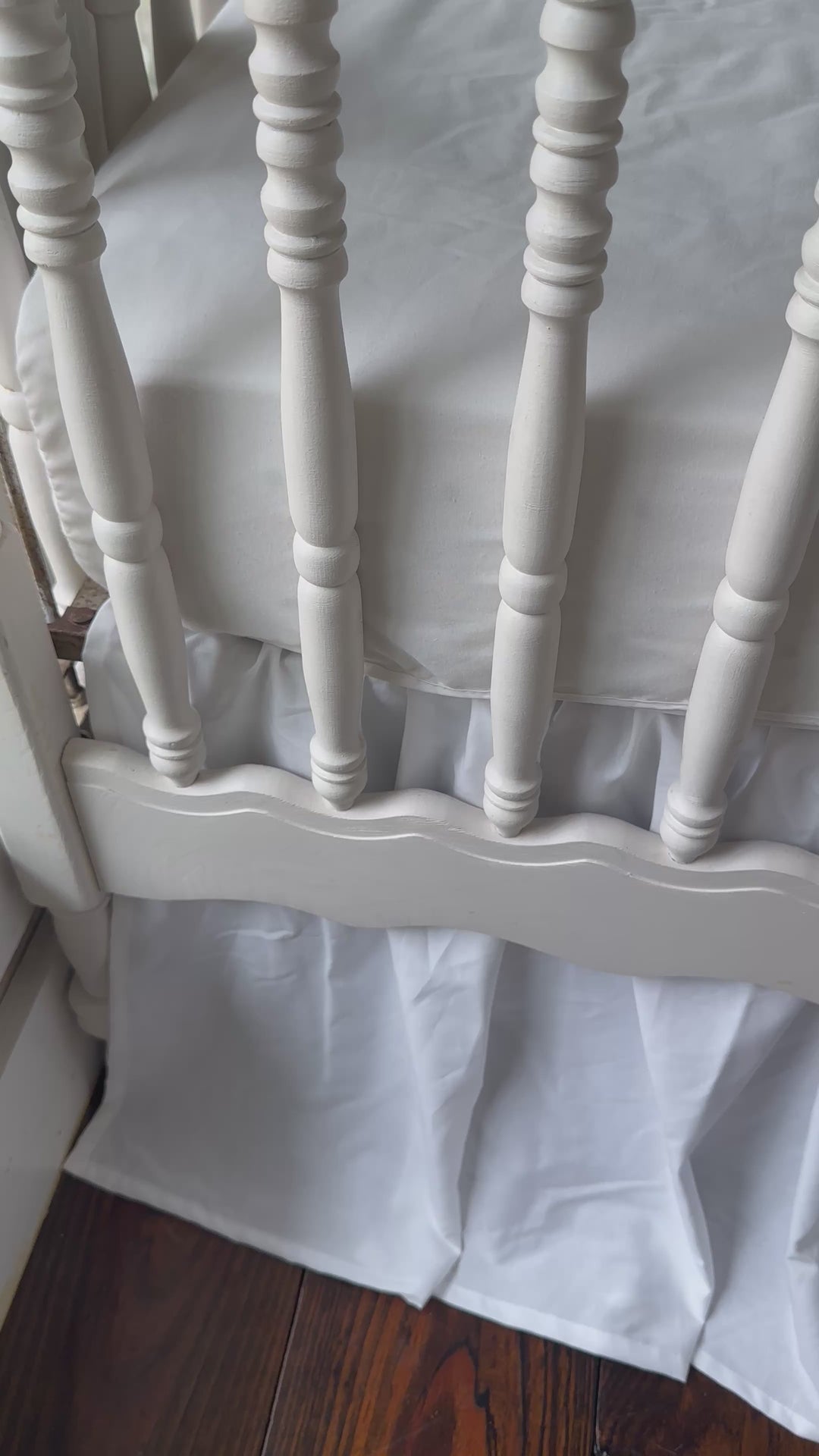 Walking video of the green dot ruffled crib rail cover, white farmhouse skirt and white bows in the nursery