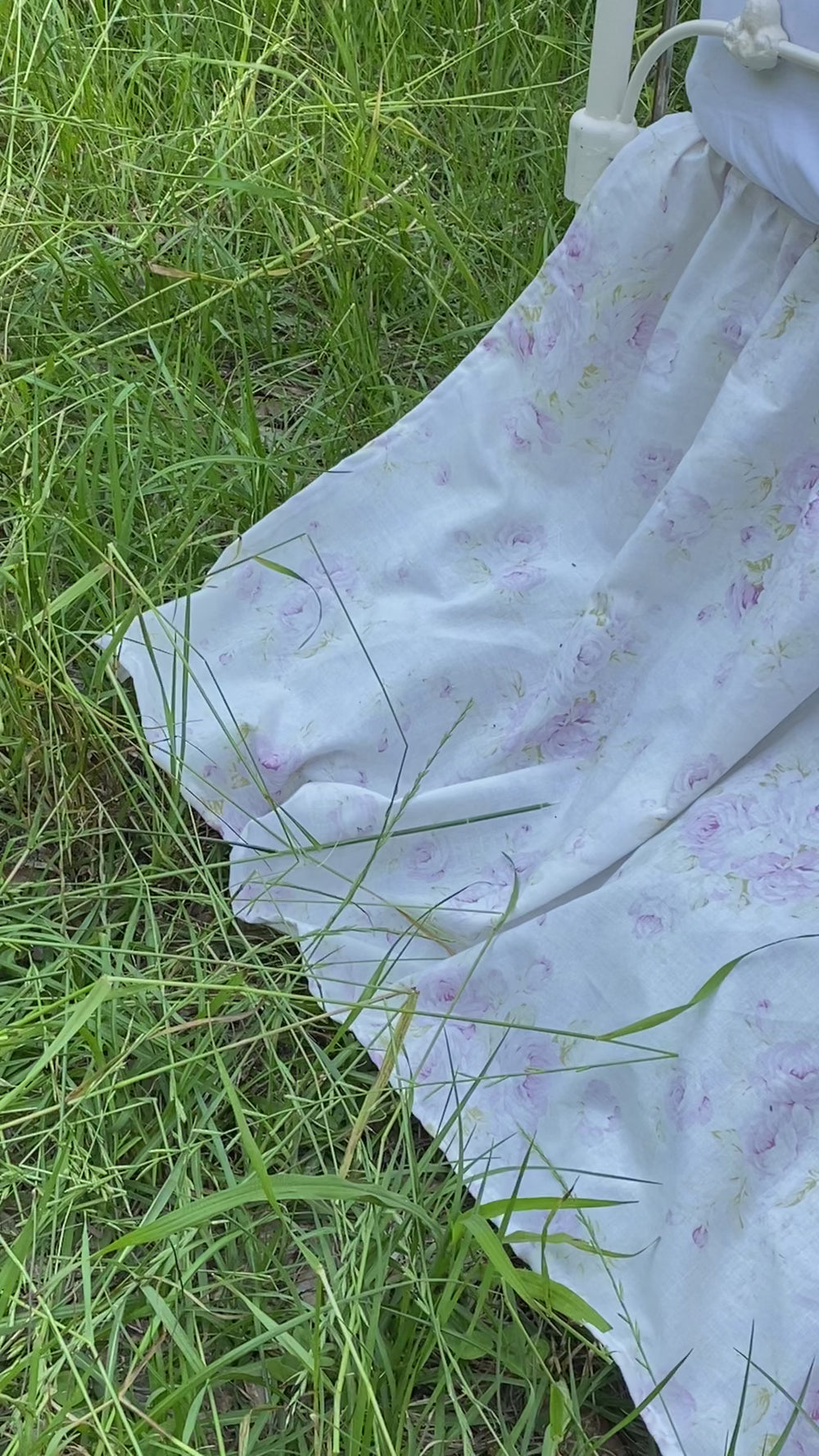 Lavender shabby chic floral gathered crib skirt on antique iron crib in field