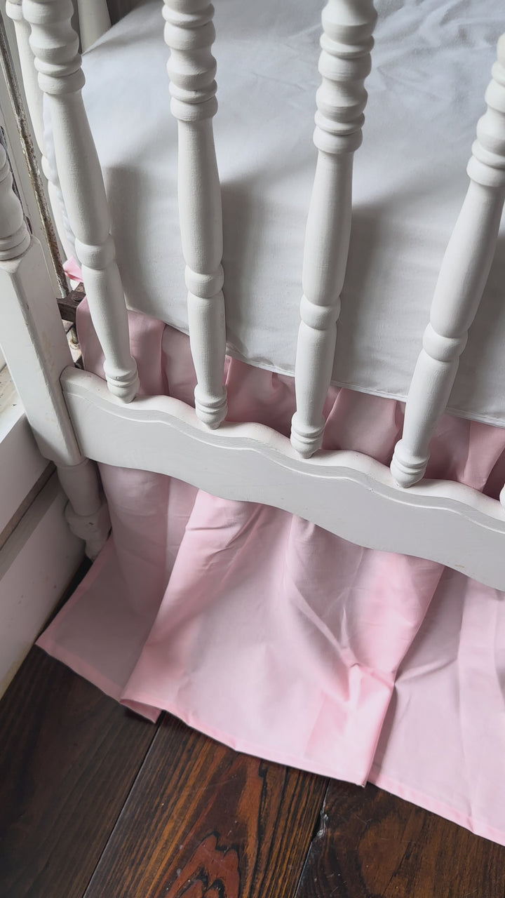Video of the Sisters Pink two-piece crib rail cover and farmhouse crib skirt set on a white crib