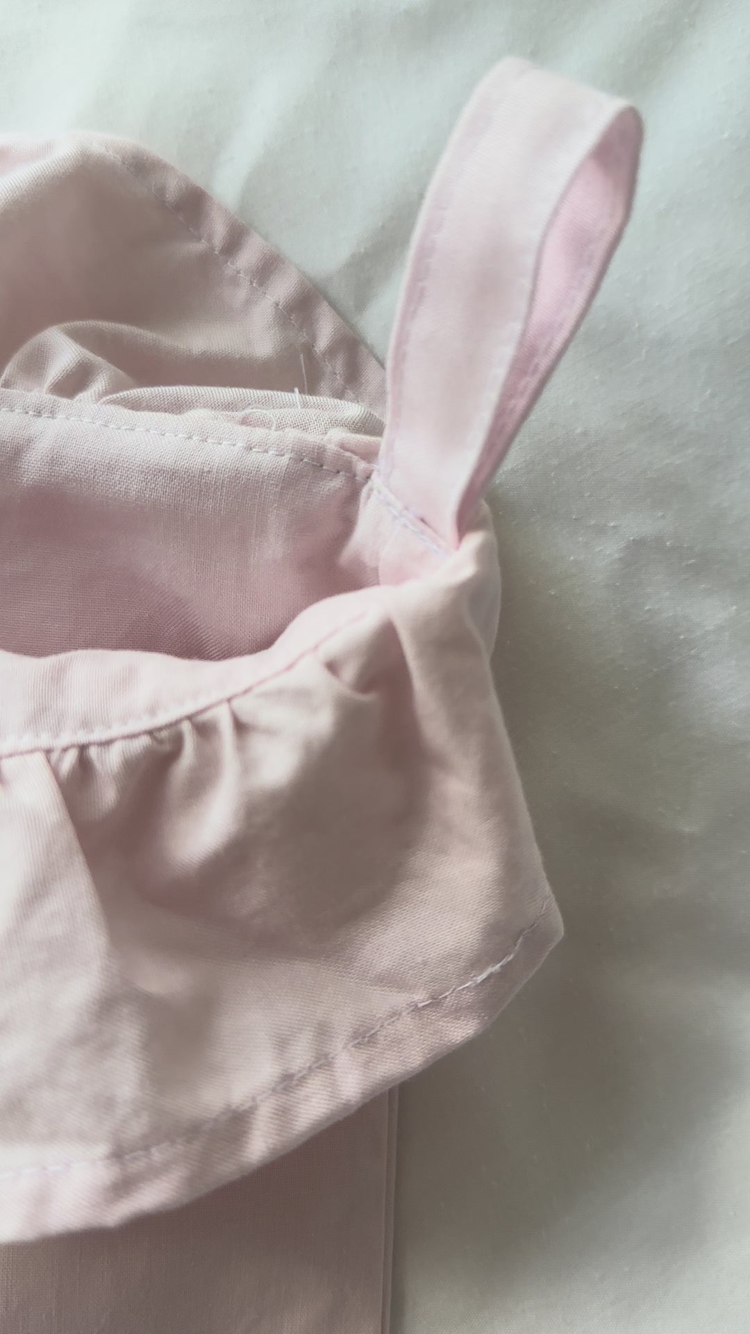 Video of baby pink ruffled Christmas stockings hanging on a mantel, showing the gathered ruffle cuffs
