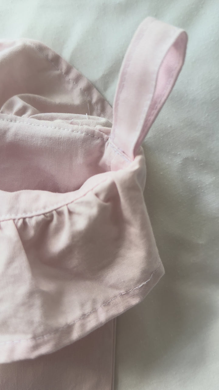 Video of baby pink ruffled Christmas stockings hanging on a mantel, showing the gathered ruffle cuffs