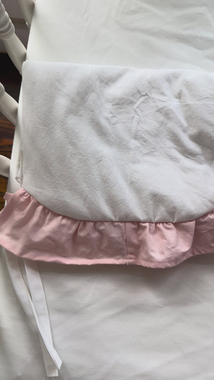 Video of the White and Sisters Pink scalloped crib rail cover on a crib rail
