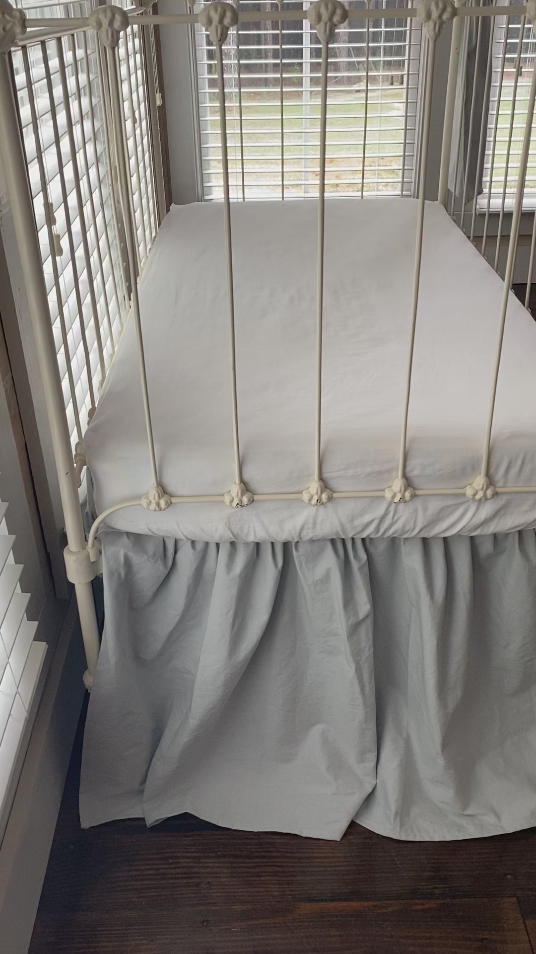 Video of the Zen grey gathered crib skirt and matching large crib bows on white iron farmhouse crib, front view, handmade in Alabama 