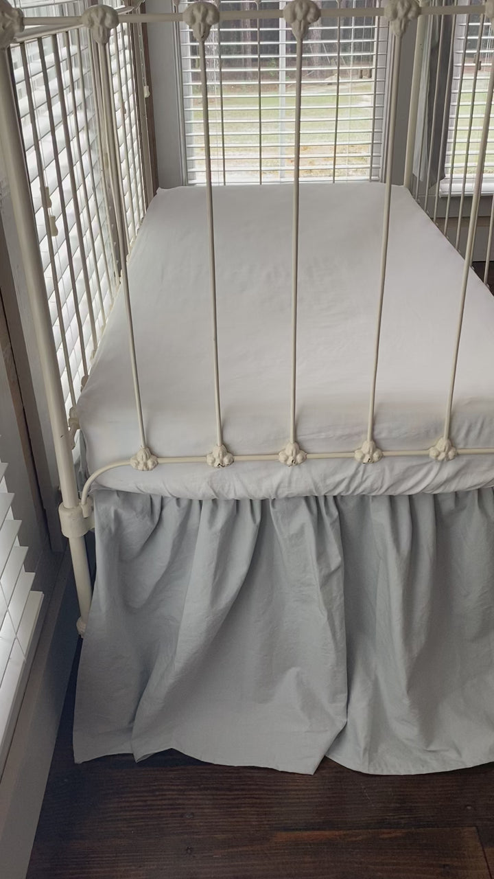 Video of the Zen grey gathered crib skirt and matching large crib bows on white iron farmhouse crib, front view, handmade in Alabama 